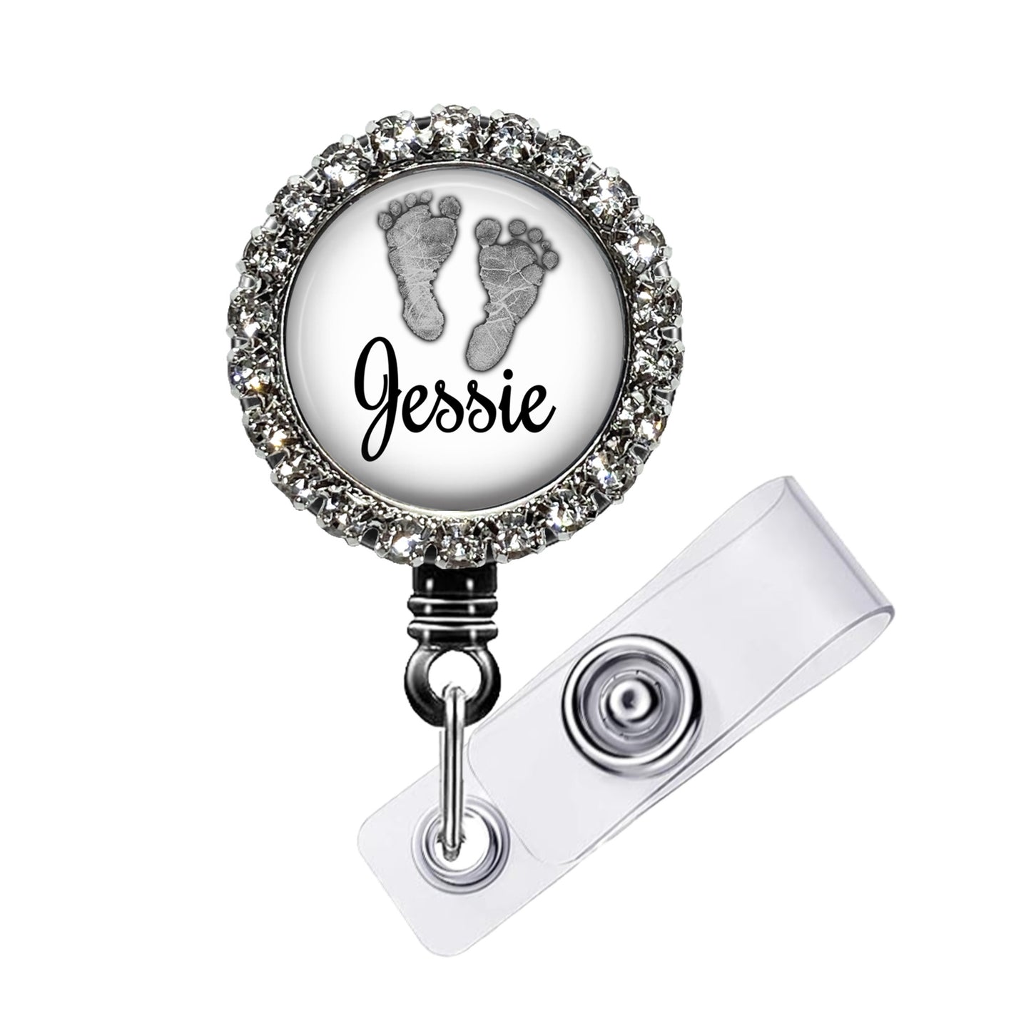 A personalized name badge with a rhinestone-encrusted frame, featuring a small image of a baby's feet and the name " Jessie" written on the frame.
