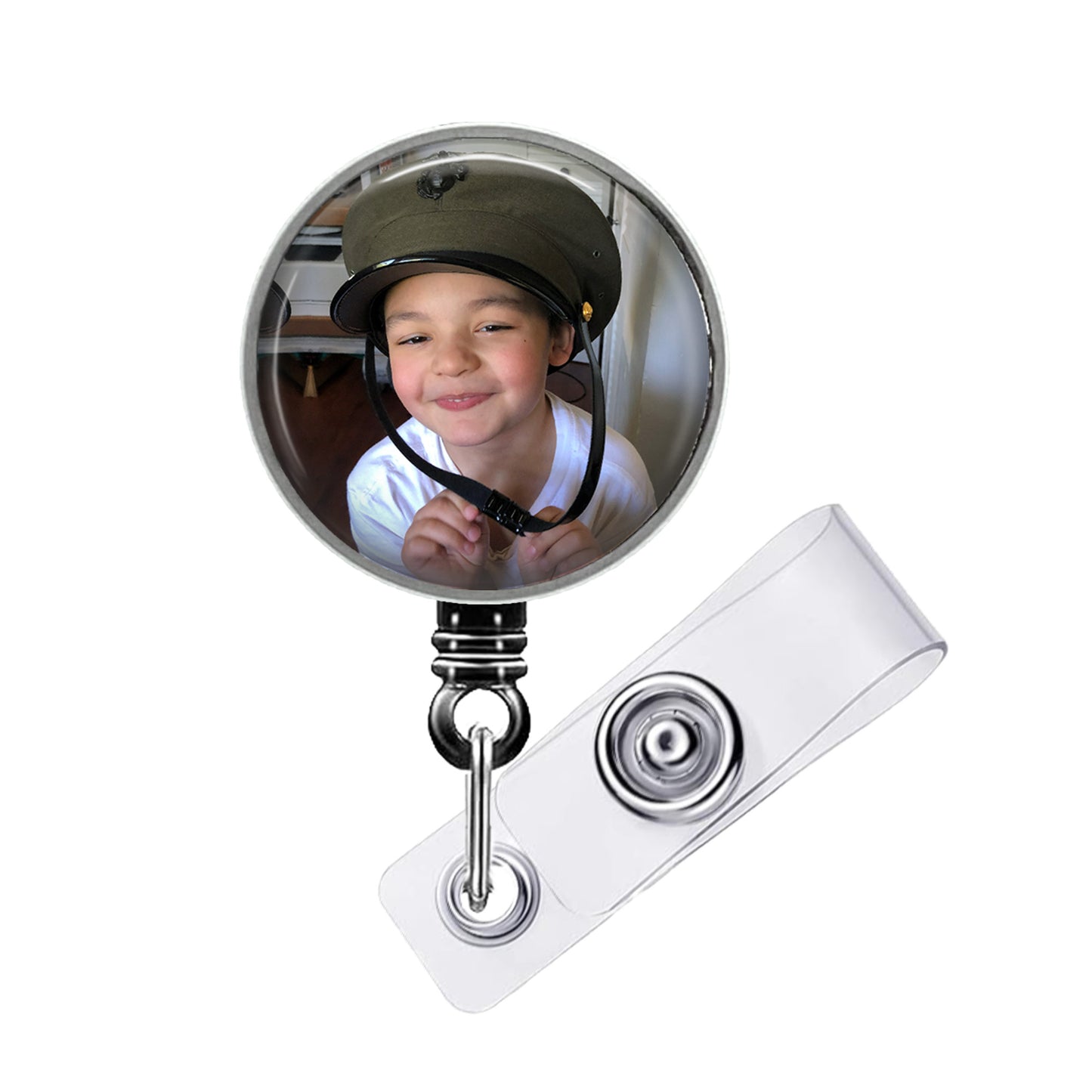 A child wearing a helmet is reflected in a round mirror attached to a badge holder.