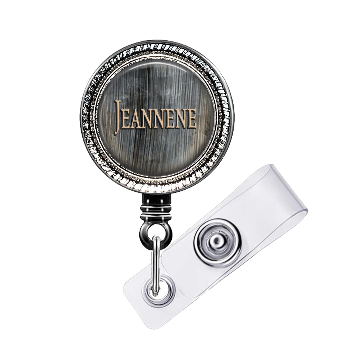 A metal badge with the name "Jeanne" engraved on it, attached to a clear plastic clip.