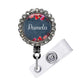 A personalized name badge with a floral design and a rhinestone-encrusted frame.