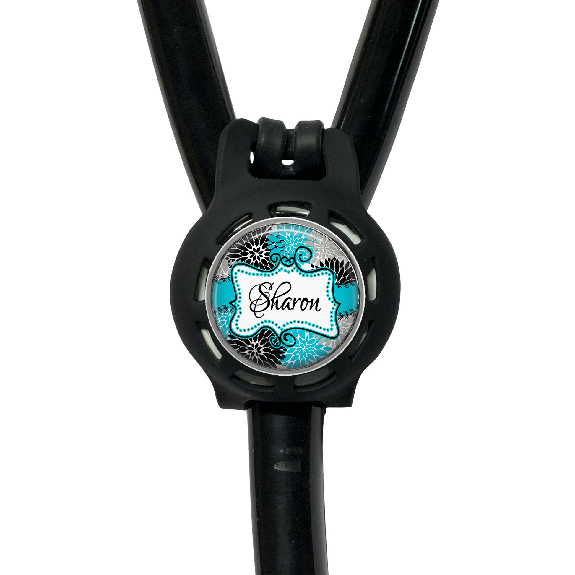 A black stethoscope with a round, personalized name badge attached to it.