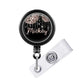 A black badge holder with a personalized name tag attached to it.