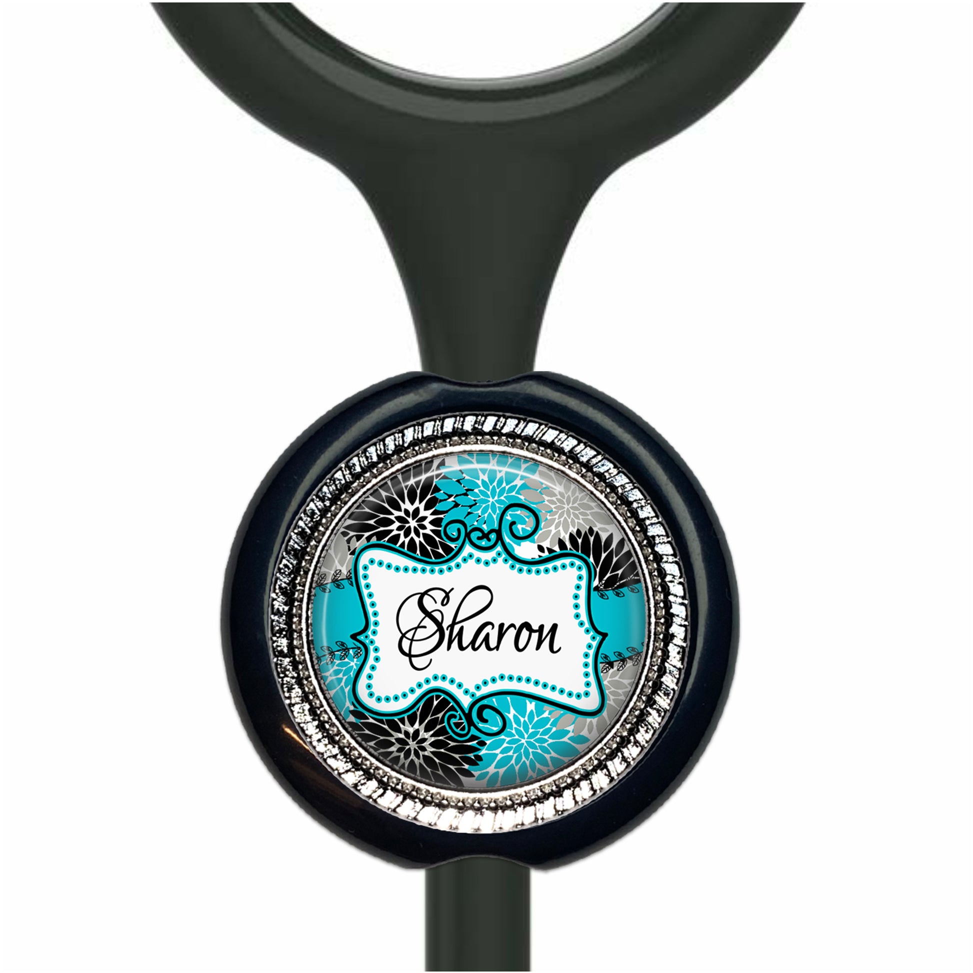 A black and blue circular charm with the name "Sharon" written on it, attached to a black handle or stem.
