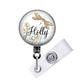A round badge holder with a dragonfly design and the word "Holly" written on it.