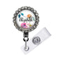 A personalized name badge with a floral design and a rhinestone-encrusted frame.