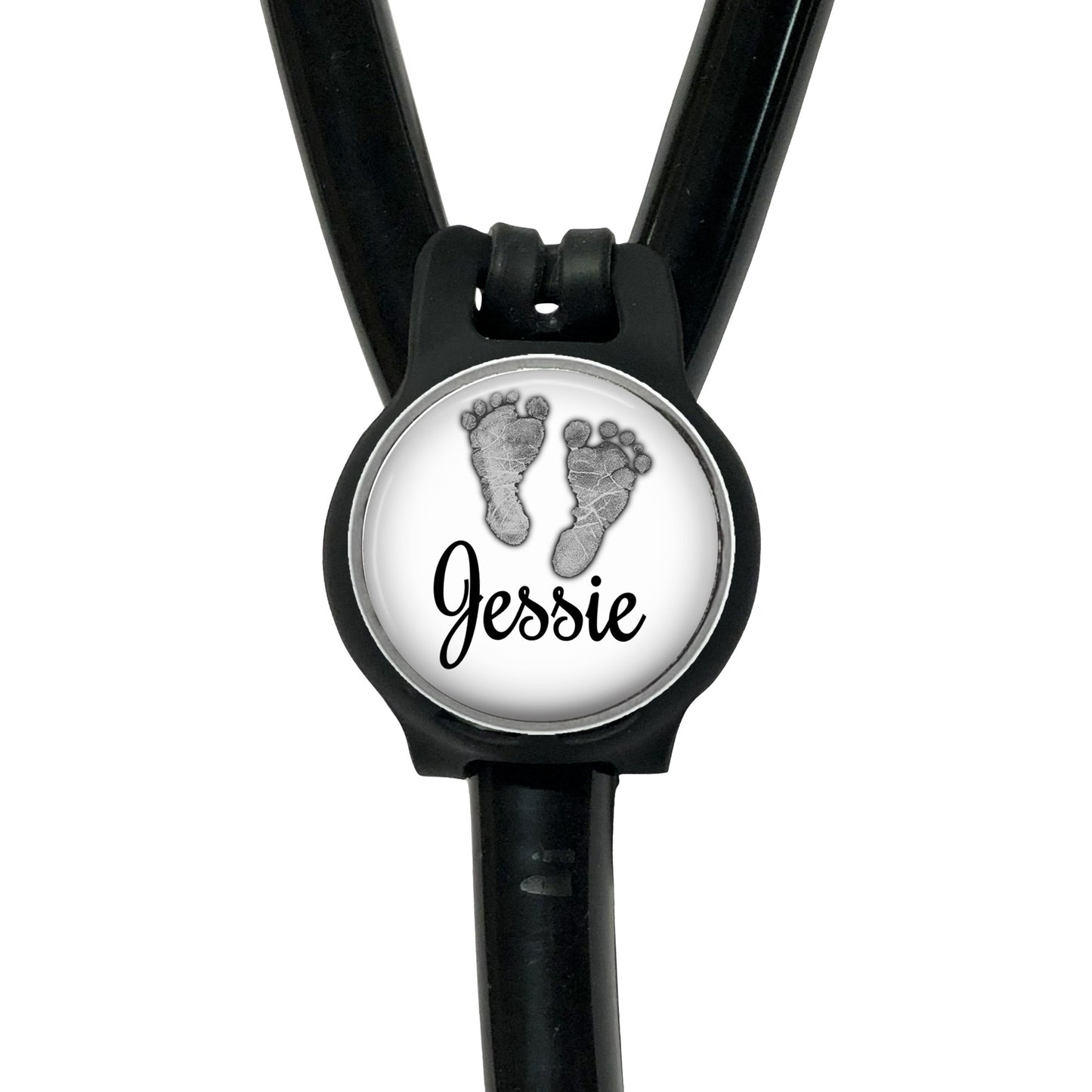A black stethoscope with a round badge featuring a pair of baby feet and the name " Jessie" written on it.