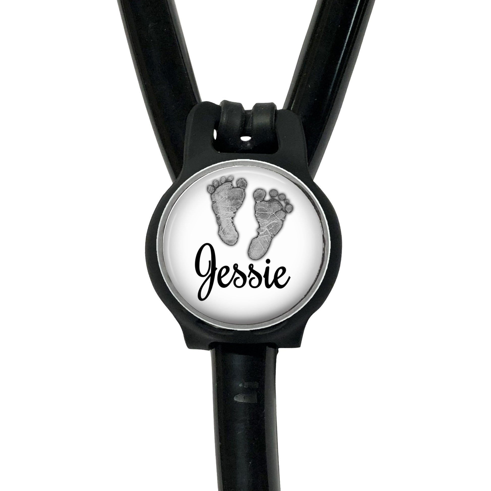 A black stethoscope with a round badge featuring a pair of baby feet and the name " Jessie" written on it.