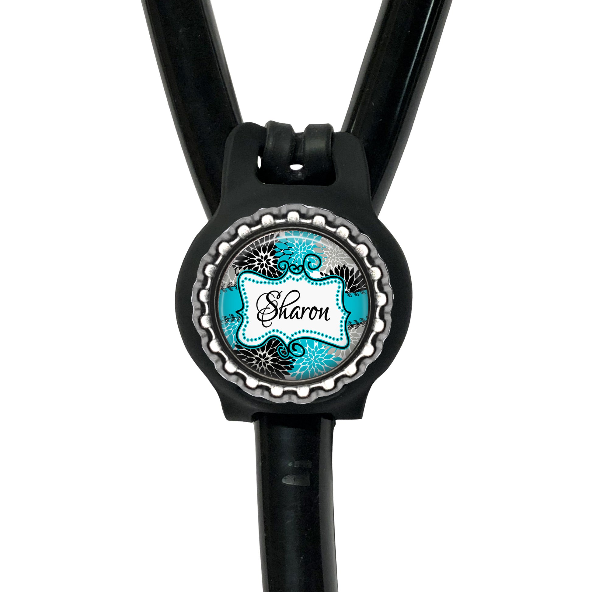 A black stethoscope with a personalized name badge attached to it.