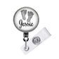 A round badge holder with a name tag attached to it. The name tag has the name "JESSIE" printed on it.