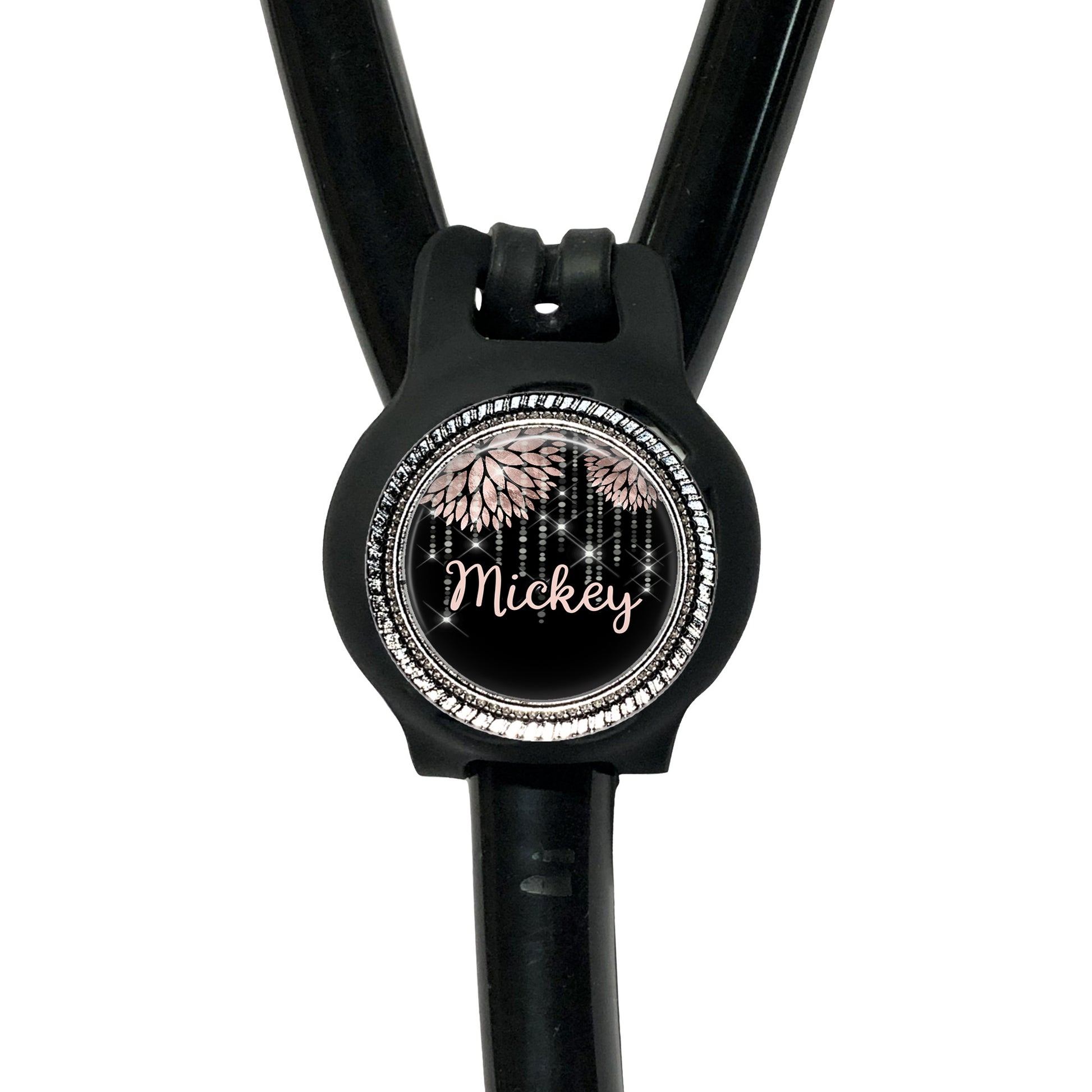 A black stethoscope with a round, personalized name tag attached to it.