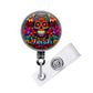 A colorful lanyard with a circular design featuring a skull and floral patterns.