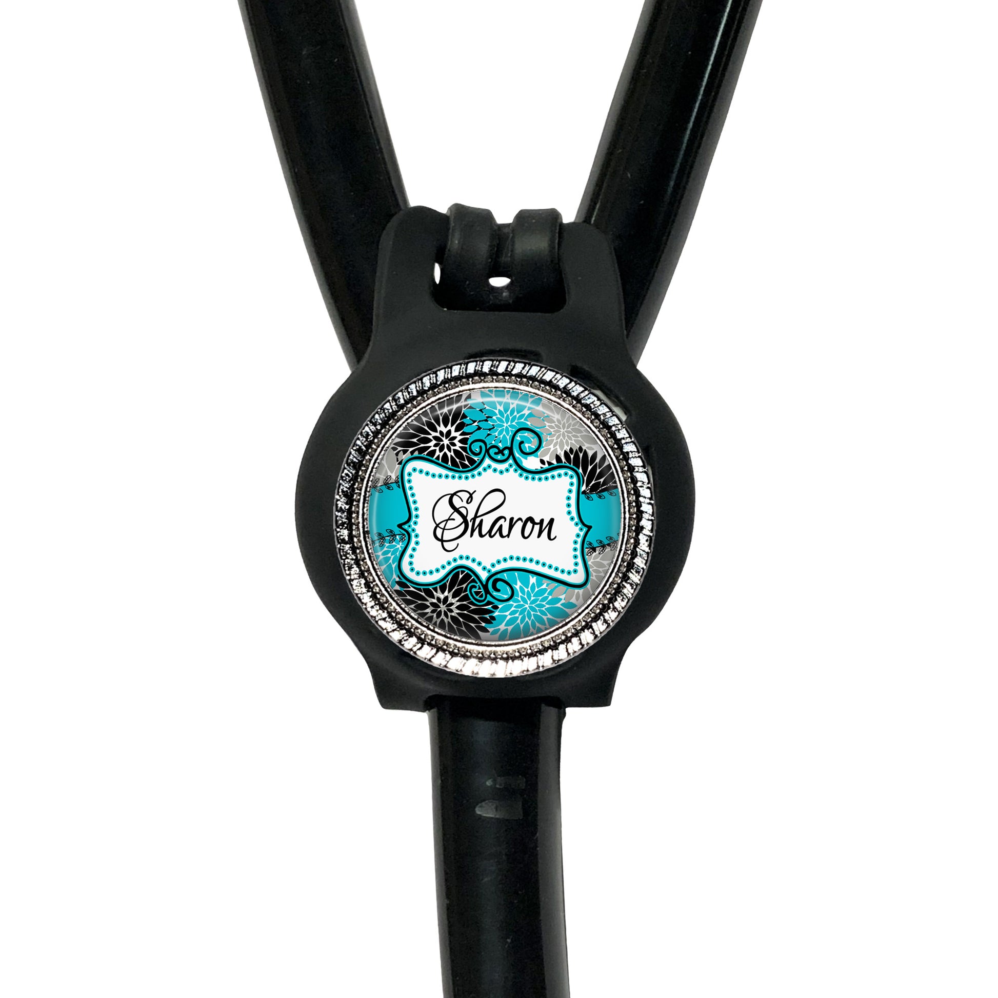 A black stethoscope with a round, personalized name tag attached to it.