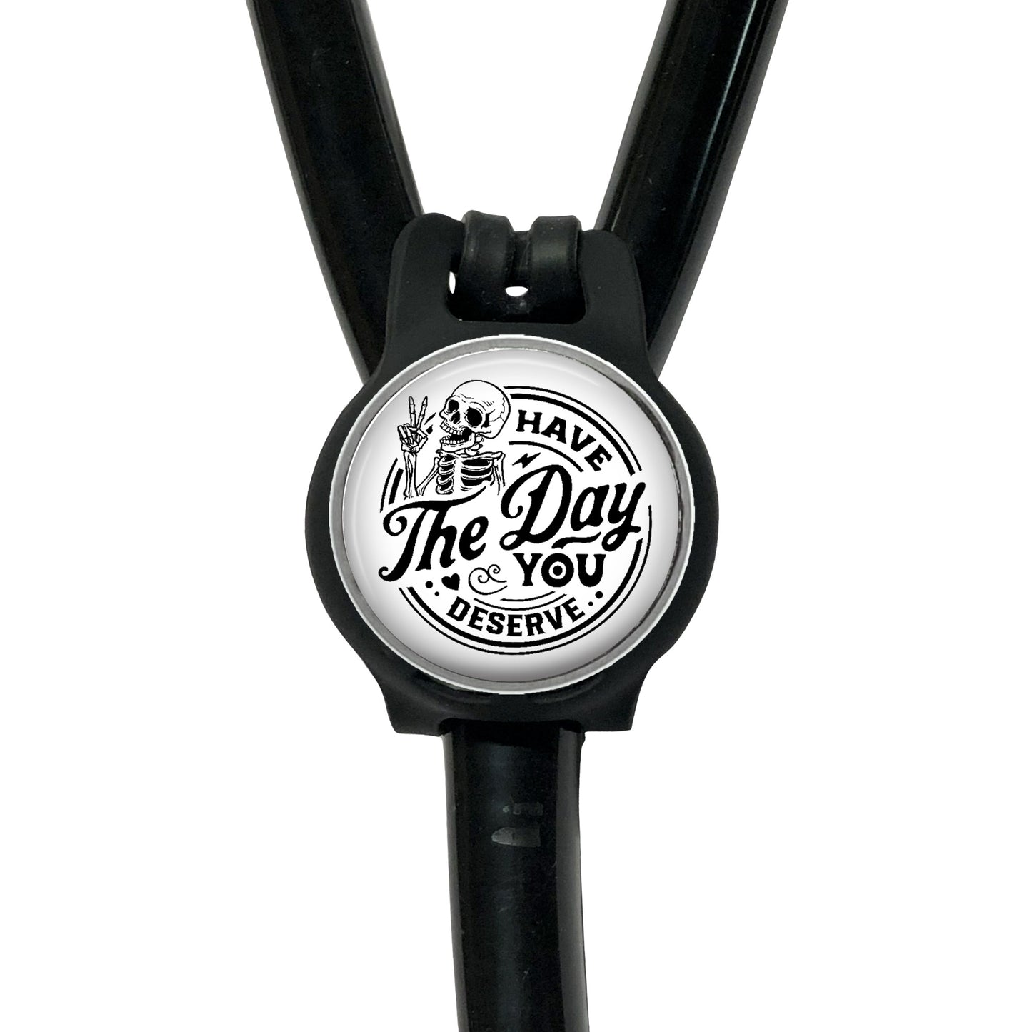 A black stethoscope with a circular badge featuring a skeleton and the text "The Day You Serve".