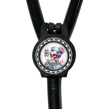 A black stethoscope with a round badge featuring a skull wearing a blue nurse's hat and the text "Coffee nurse prep" printed on it.