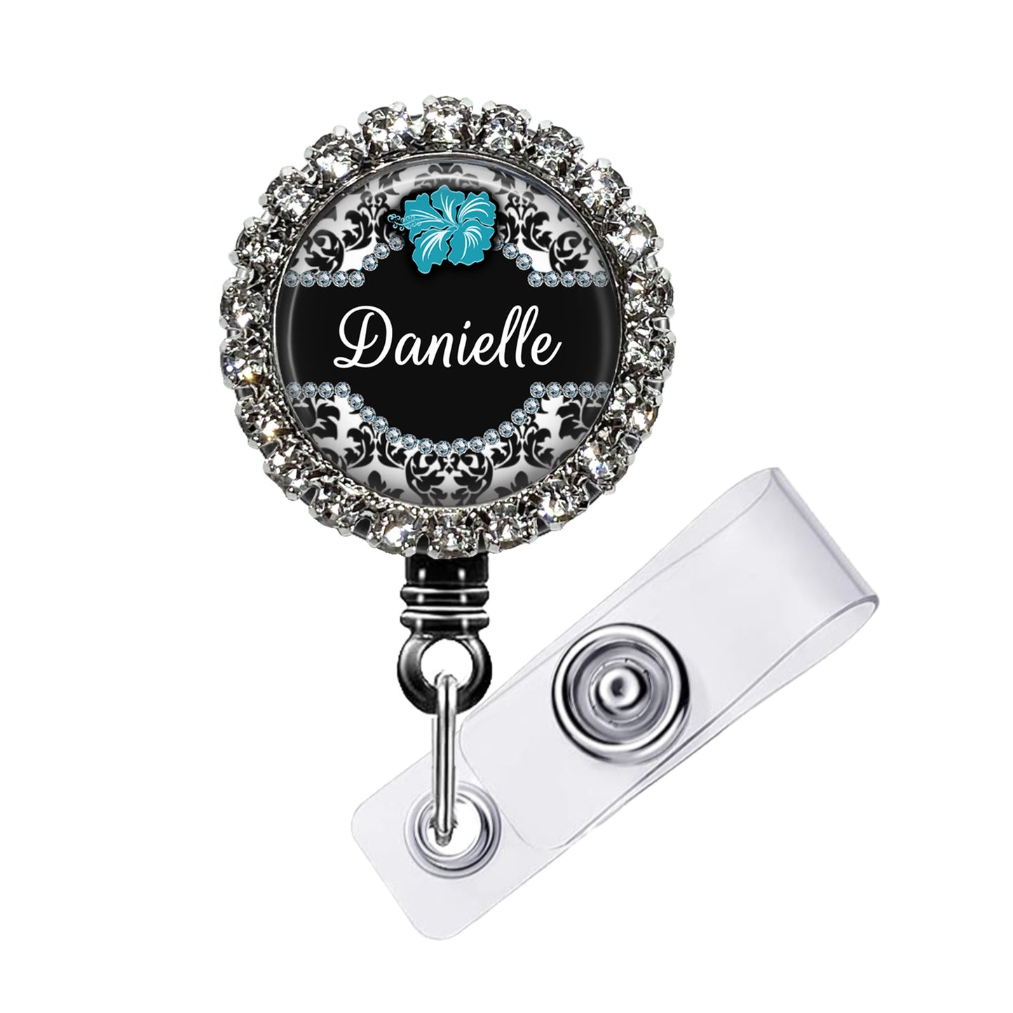 A personalized name badge with a black background, silver rhinestones, and a blue hibiscus flower design.