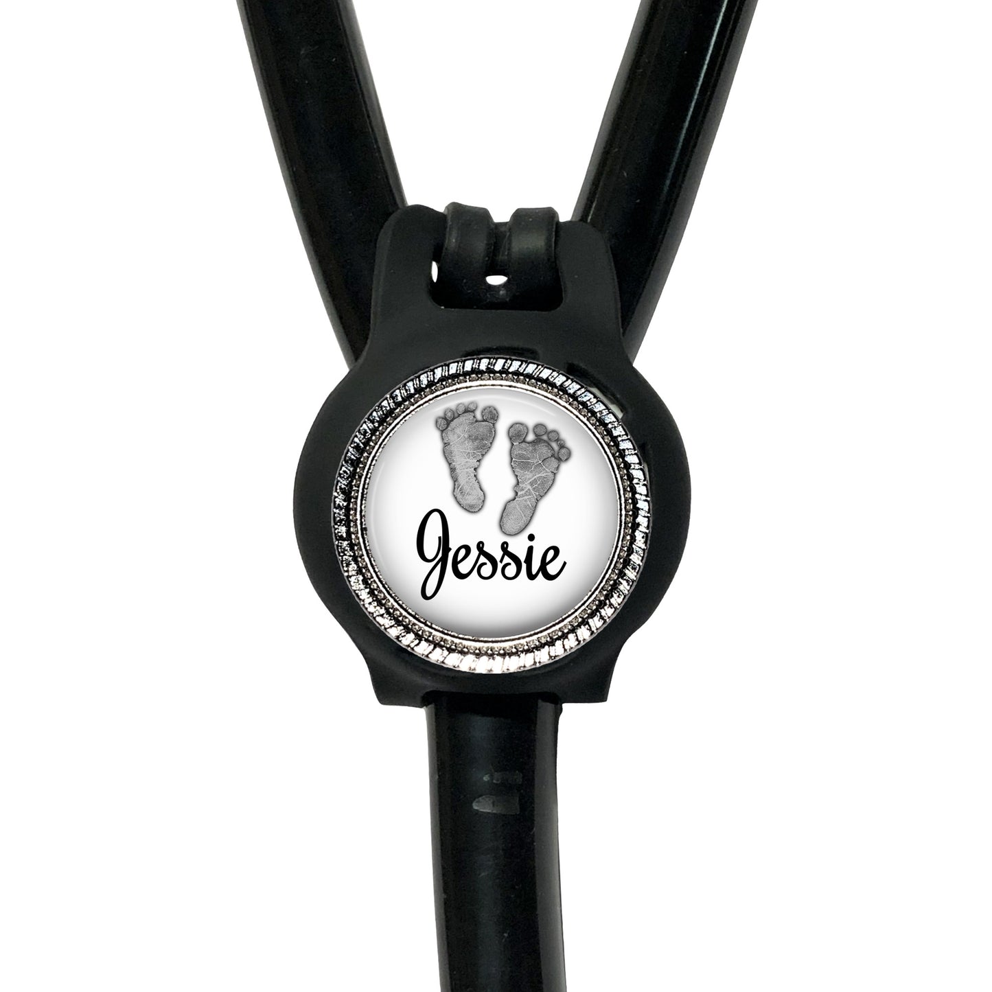 A black stethoscope with a round badge on the front, featuring a pair of footprints and the name " Jessie" written on it.