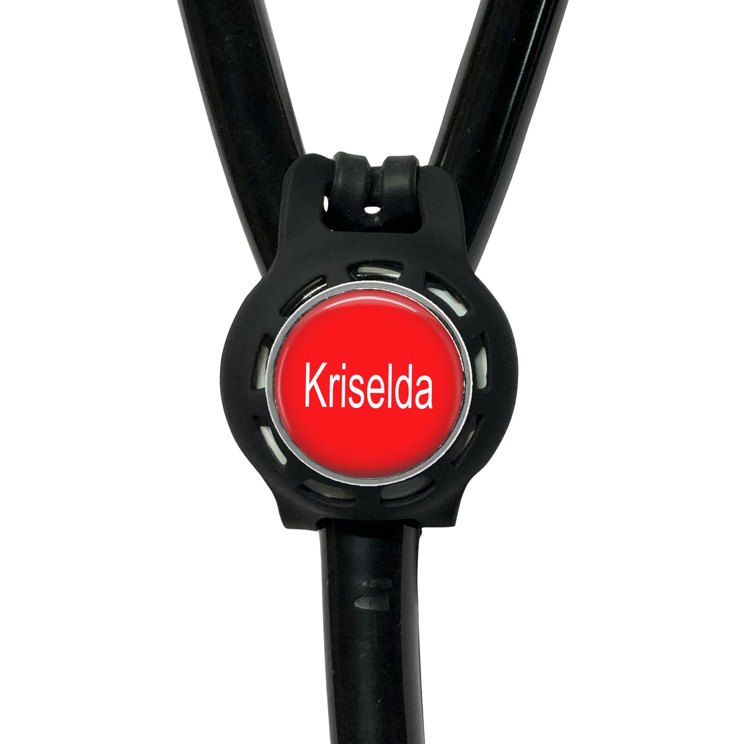 A red circular button with the name "Krisela" written on it, attached to a black strap or cord.