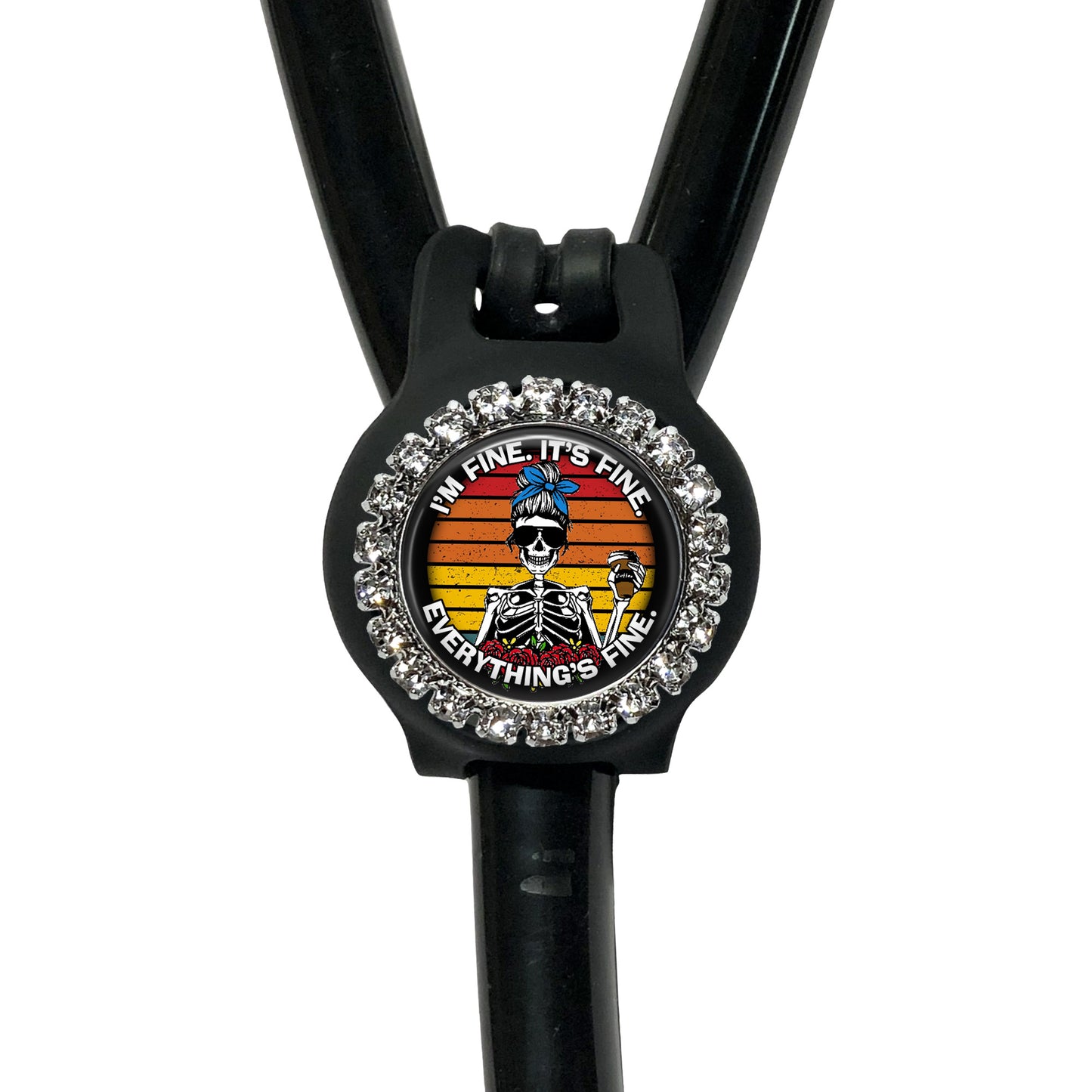 A black medical device with a decorative charm featuring a skeleton wearing a blue hat and the text "I'm fine, everything's fine" around the charm.