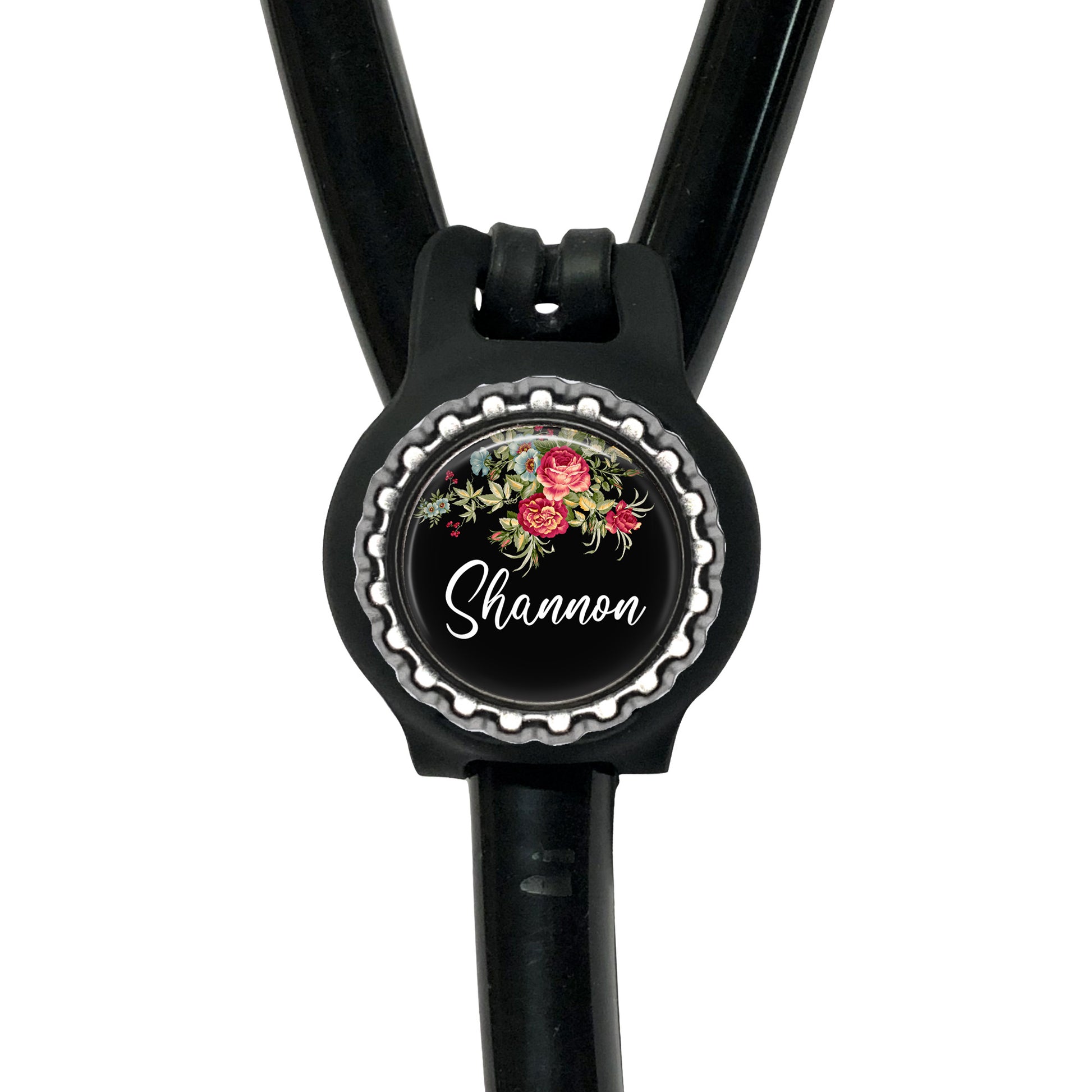 A black stethoscope with a round, floral-designed badge that says "Shannon" on it.