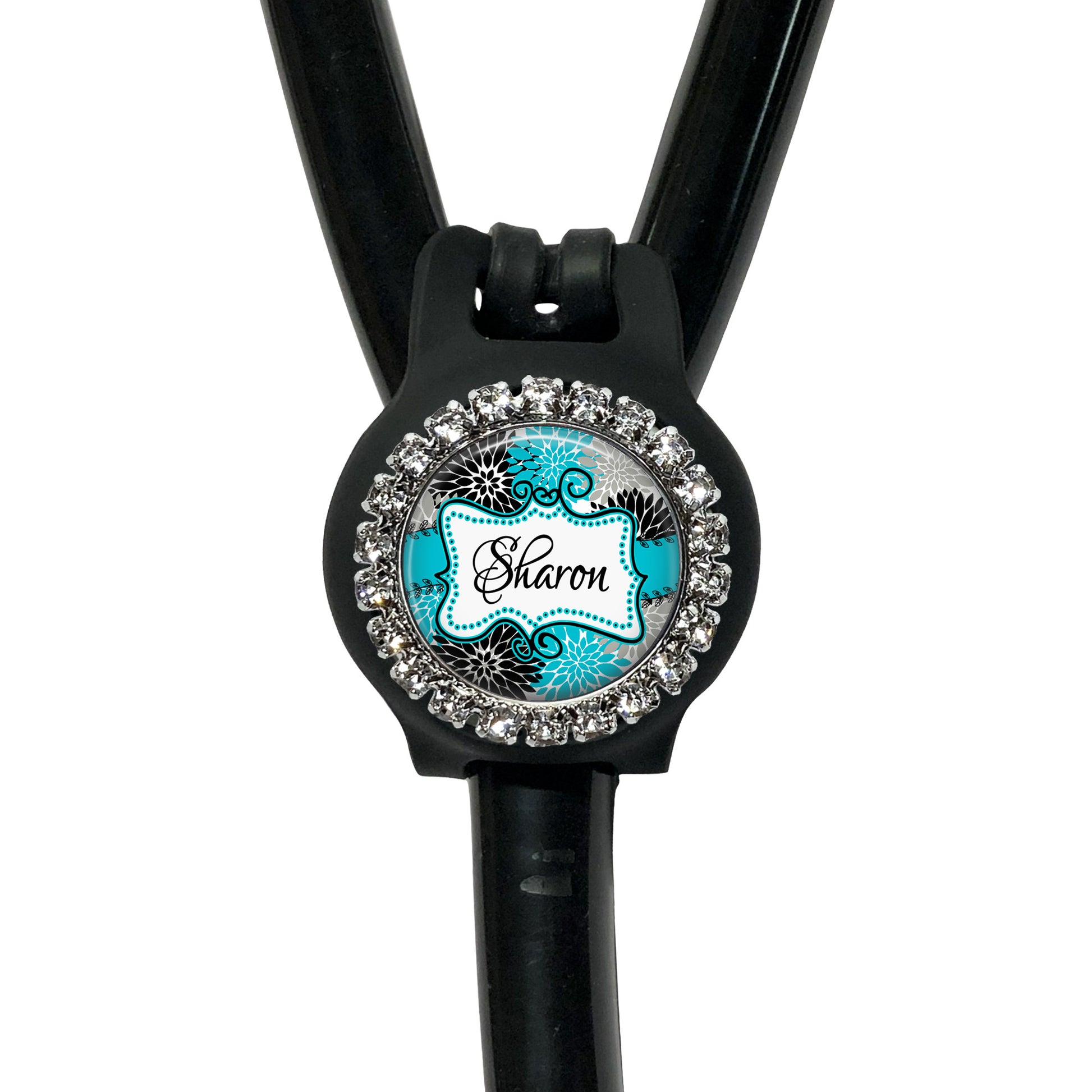 A black stethoscope with a personalized name badge attached to it.