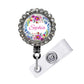 A personalized name badge with a floral design and the name "Sophia" printed on it. The badge is attached to a clear plastic holder with a metal clasp.
