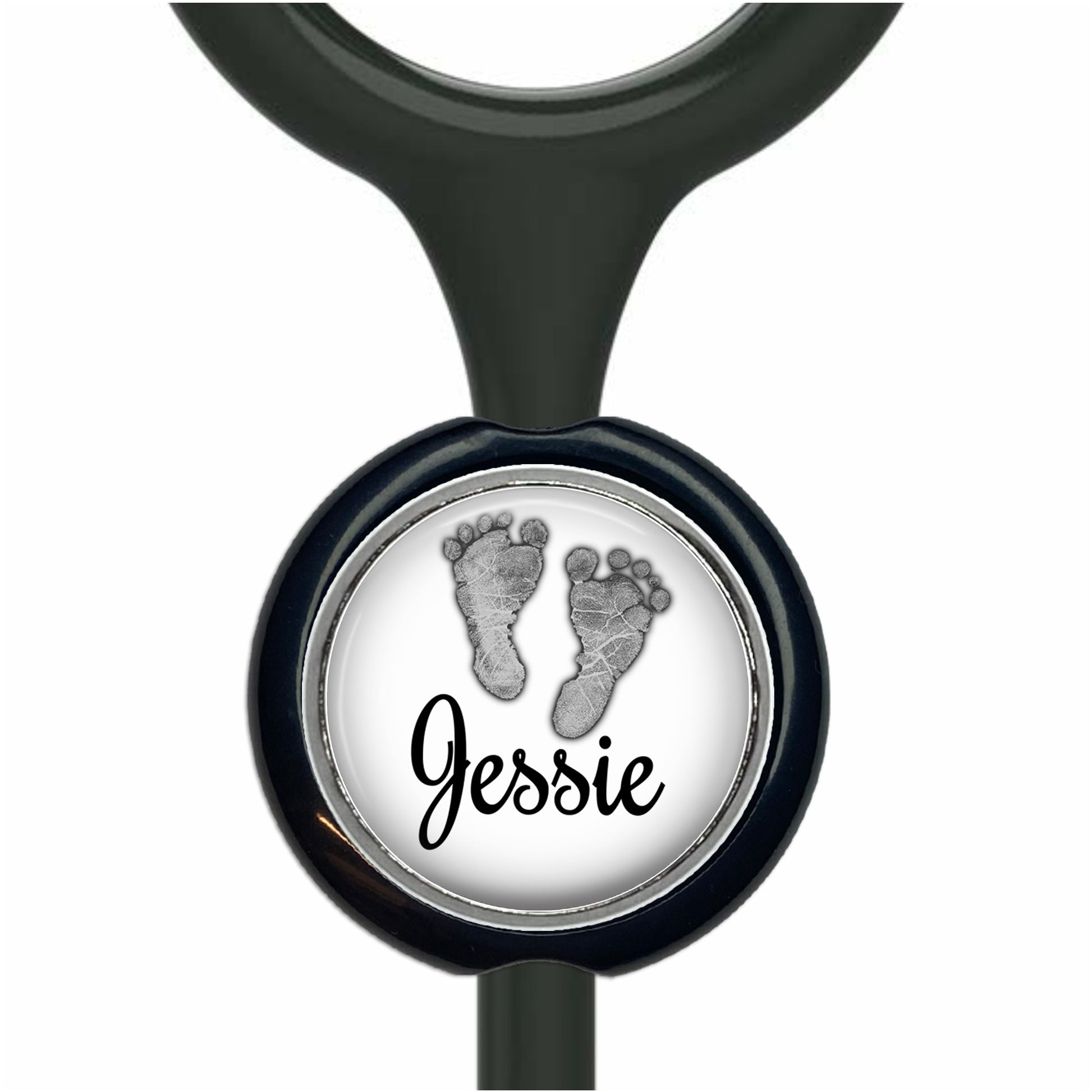 A black stethoscope with a round metal charm featuring a black and white image of a baby's foot and the name " Jessie" written below it.