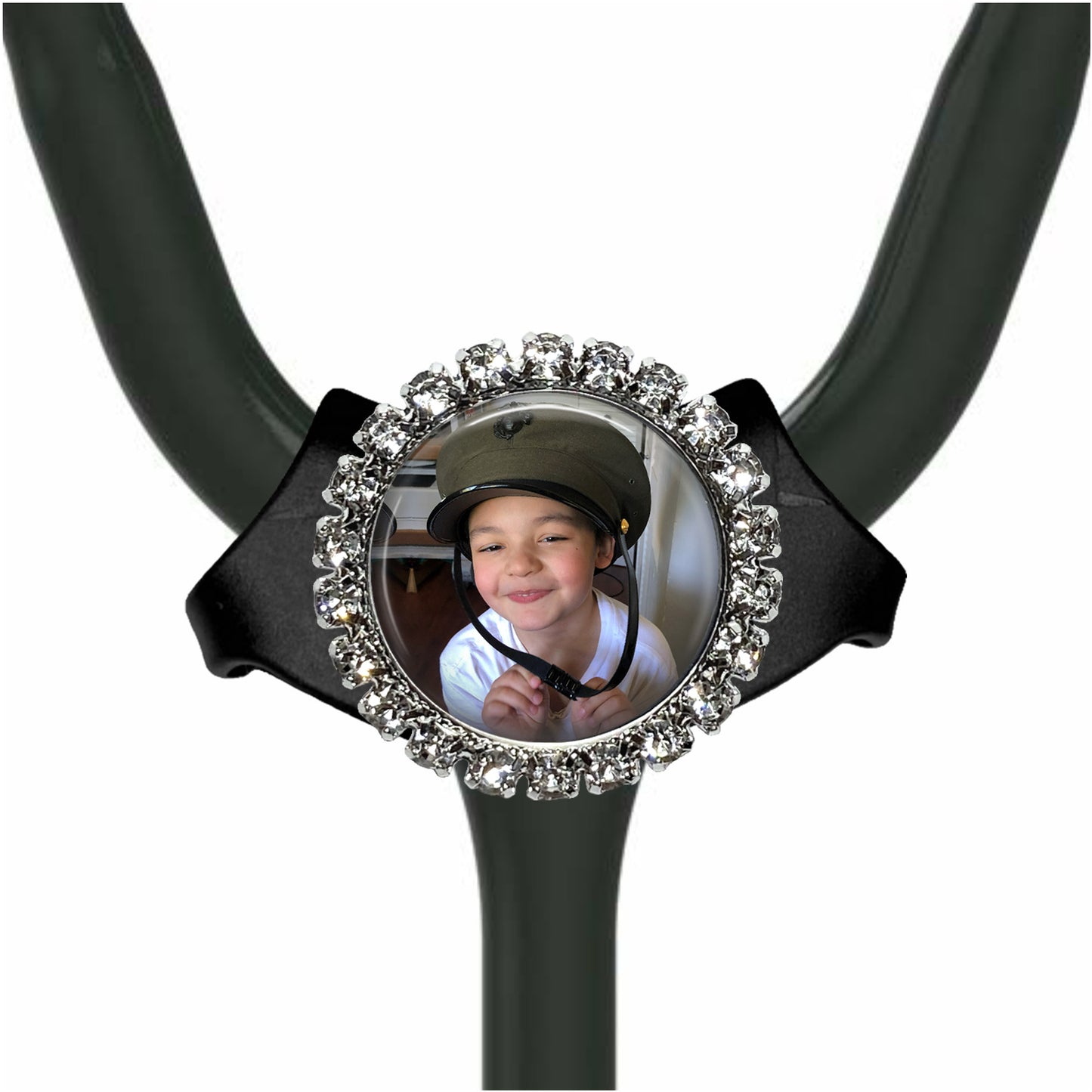 A young boy wearing a helmet is smiling at the camera, with a sparkling rhinestone-encrusted frame around the photo.