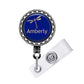 A blue badge with a dragonfly design and the word "Amberly" printed on it.