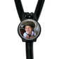 A young boy wearing a helmet is smiling at the camera, with a black stethoscope featuring a circular mirror attached to it.