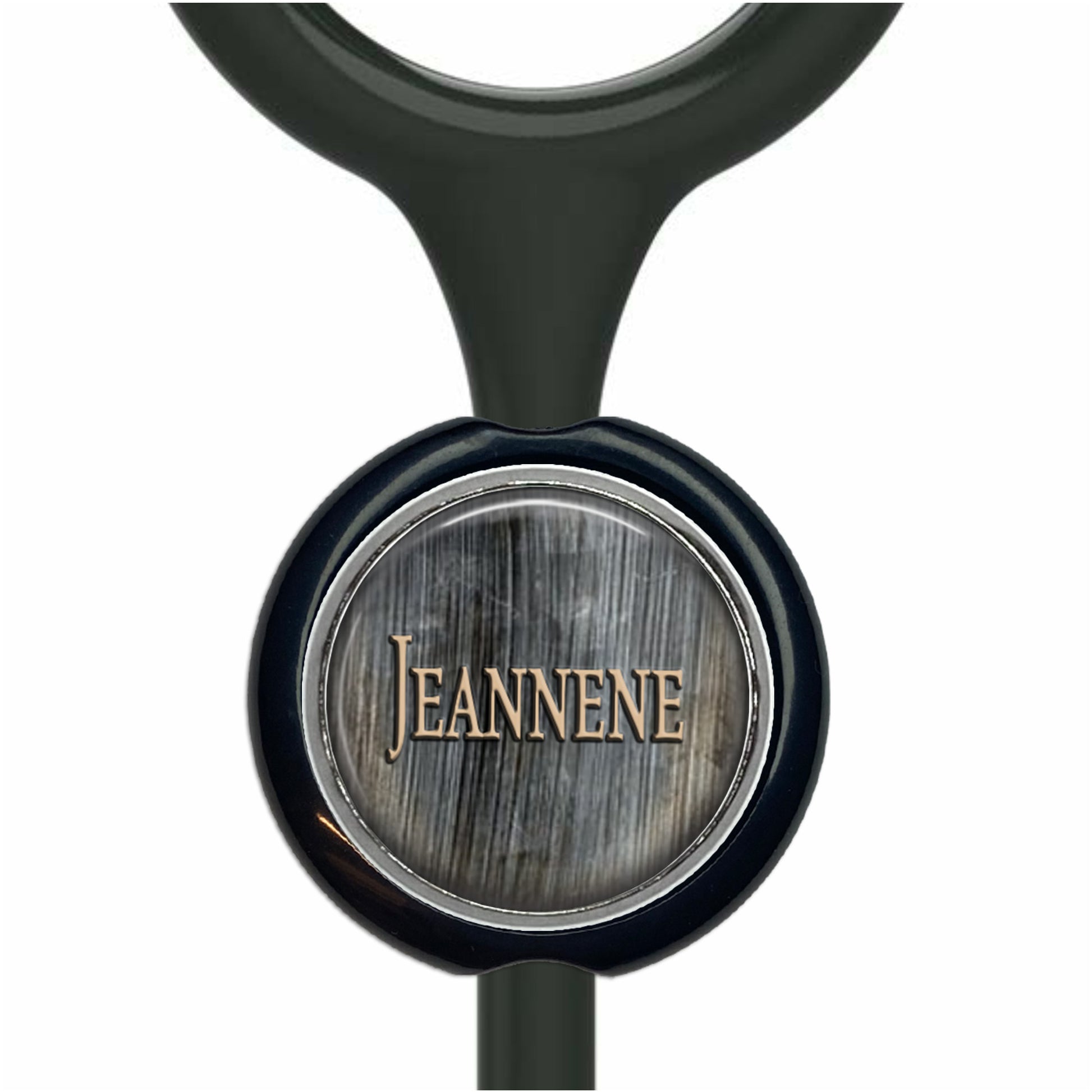 A black stethoscope with a round metal badge featuring the name "Jeanne" printed on it.