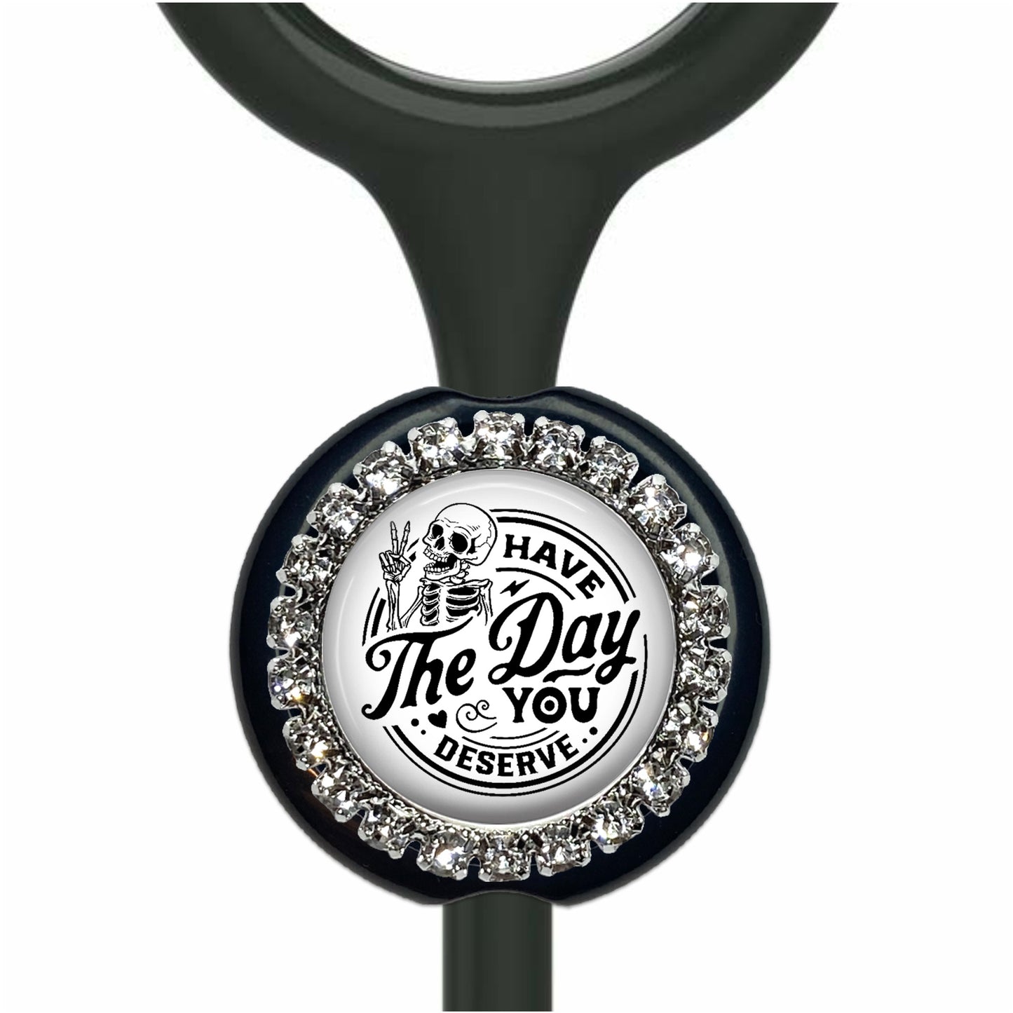 A black and white medical device with a decorative charm featuring a skeleton and the text "Have a Day, You Deserve".