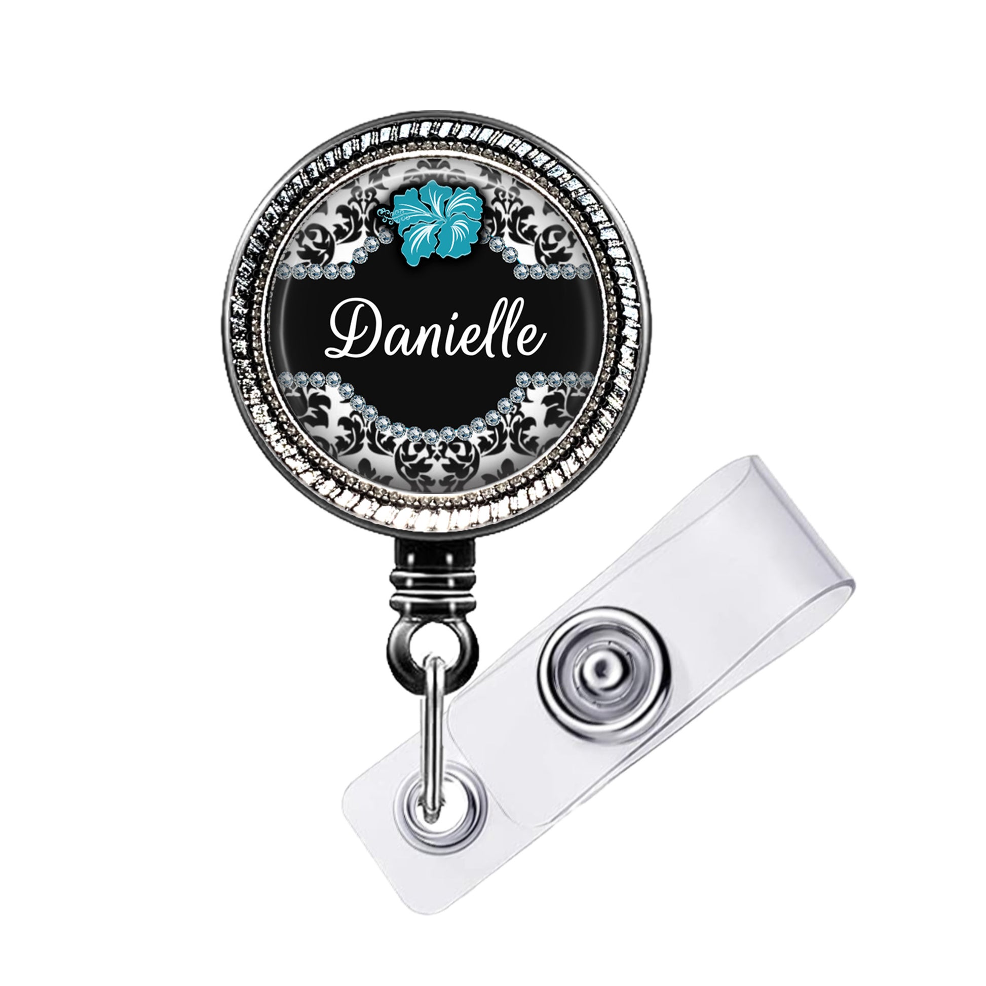 A personalized name badge with a black background and a silver frame, featuring a blue hibiscus flower design.