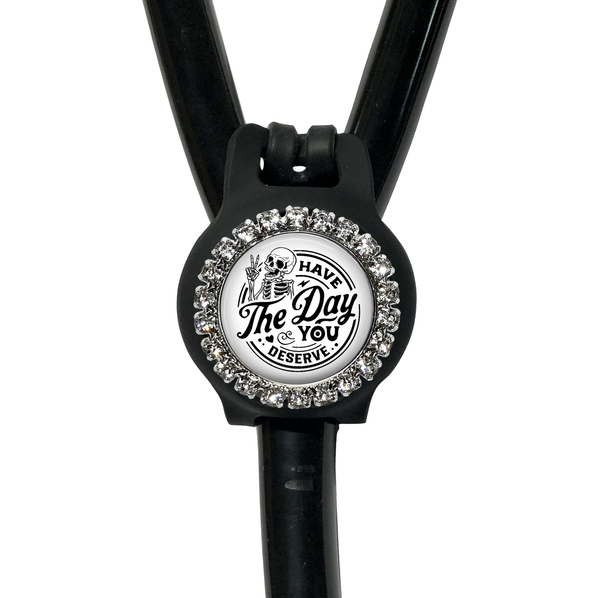 A black and white medical device with a decorative charm featuring a skeleton and the text "The Day You Deserve".