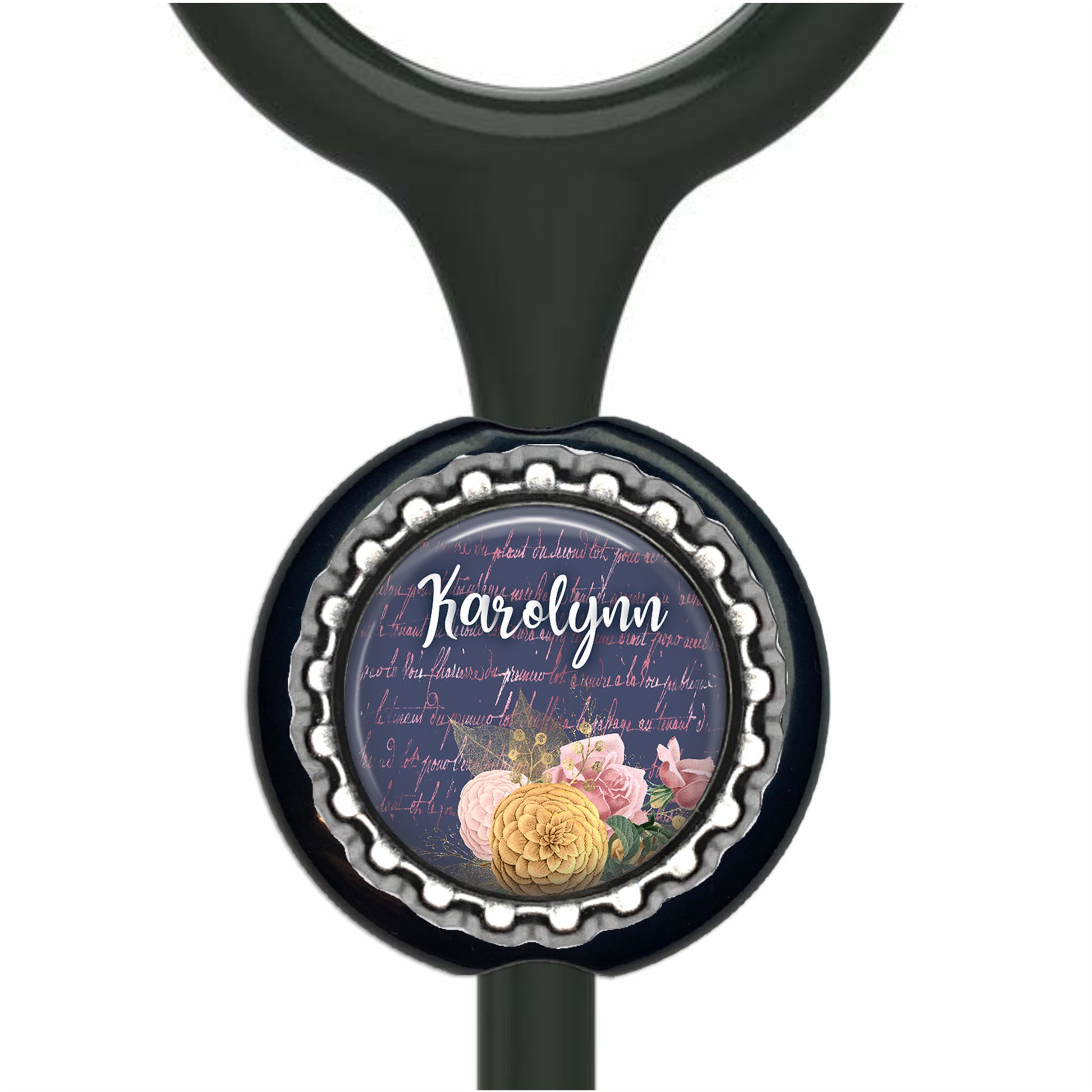 A black stethoscope with a decorative bottle cap charm featuring a floral design and the name "Karen" written on it.