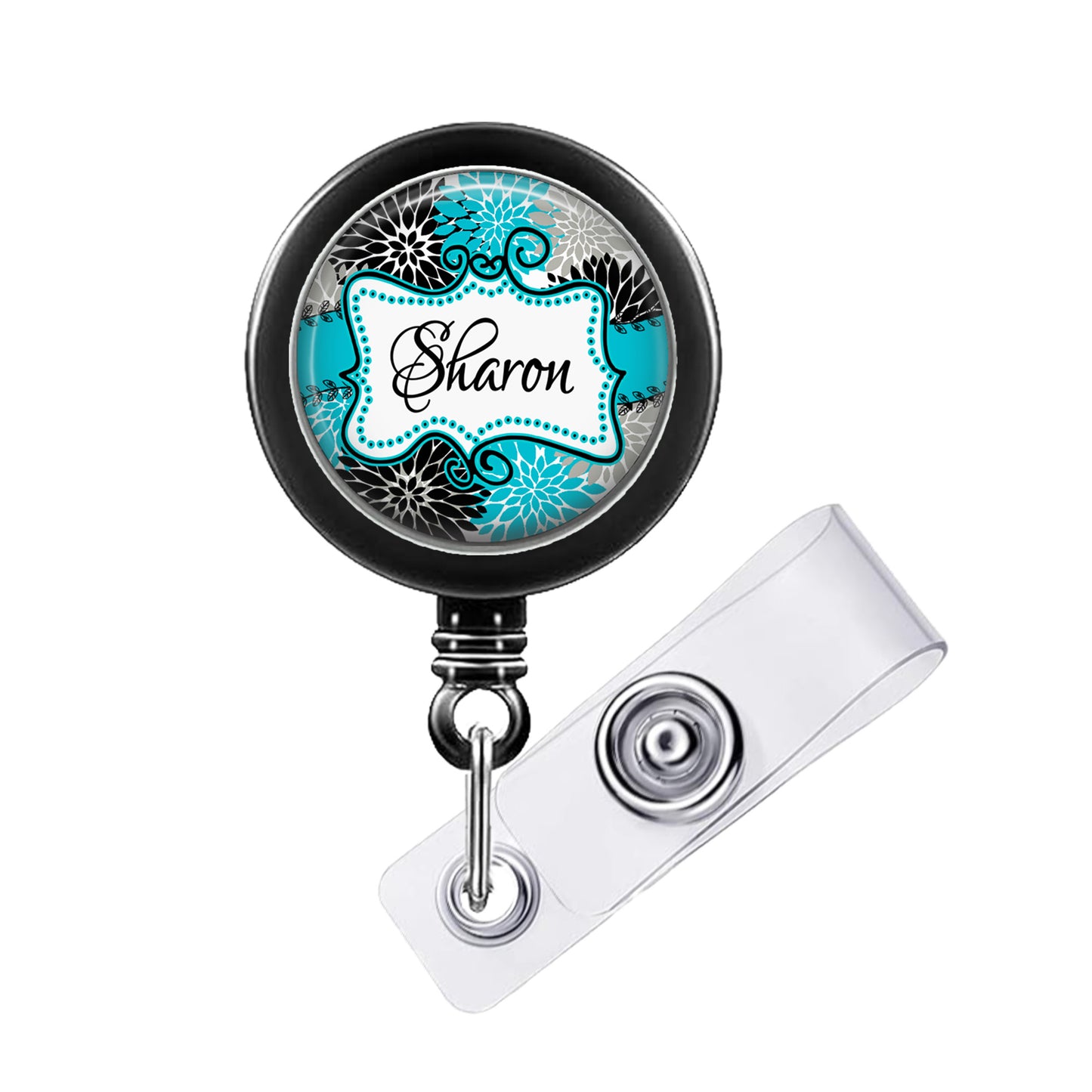 A black badge holder with a turquoise floral design and the name "Sharon" printed on it.