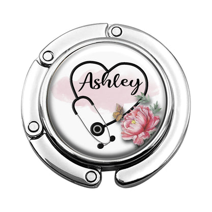 a white clock with a pink flower and a stethoscope